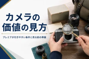 古いフィルムカメラと元箱を並べてルーペで刻印を確かめる手元