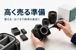 一眼レフのほこりをブロアーで飛ばし、交換レンズや付属品をそろえて買取の準備をしている手元