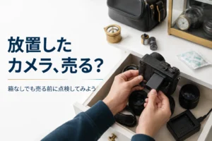 引き出しから出した小型ミラーレスカメラにバッテリーを入れて点検する手元