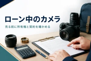 ミラーレスカメラの横で契約書の内容を確かめる手元
