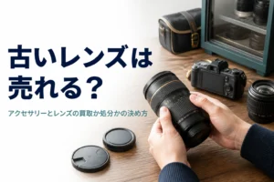 古い交換レンズとカメラのアクセサリーを並べて売るか処分するか考えている様子
