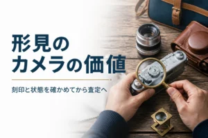 古いフィルムカメラの上面の刻印をルーペで確かめている様子