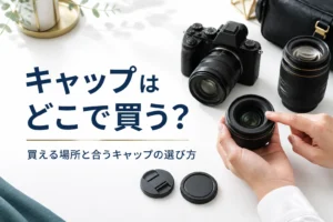 一眼レフと交換レンズの横にレンズキャップとボディキャップを並べ、合うサイズを確かめている様子