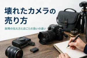 故障したカメラを机に並べ、症状をメモして買取の準備をしている様子
