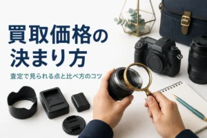 一眼レフと交換レンズ、付属品を並べて、ルーペで状態を確かめている様子
